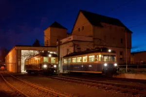 Die Triebwagen T3 (Bj 1938, rechts) und T5 (Bj 1956, rechts) stehen bereit zur abendlichen Mondscheinfahrt. Sie kommen – wohlig geheizt – für die Mondscheinfahrten im Winter zum Einsatz. Foto: Freundeskreis Trossinger Eisenbahn